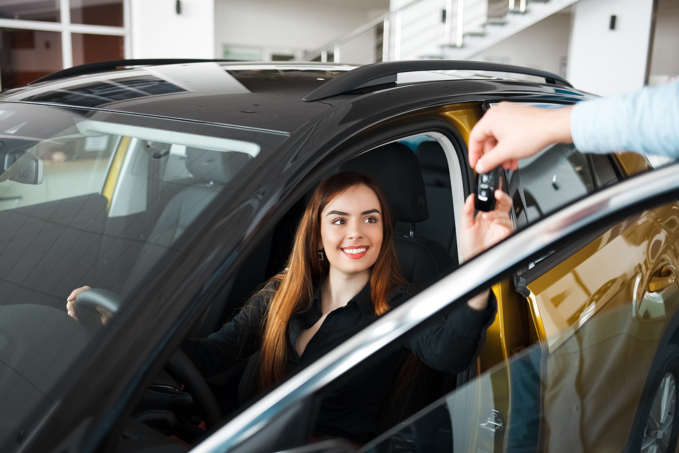 Woman Getting Key to New Car at the Dealership 